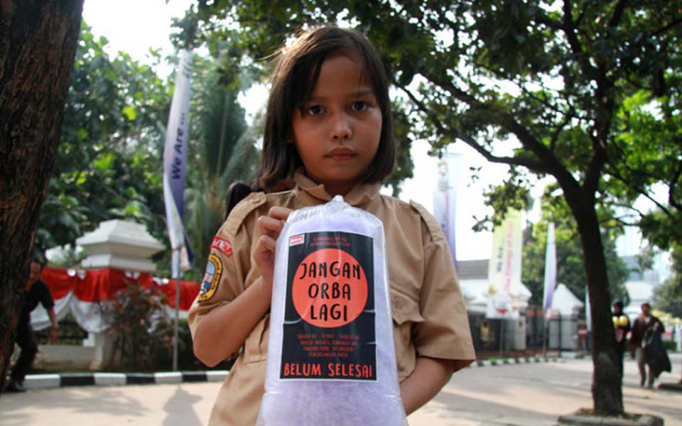 Child holds message reading 'New Order Never Again' (Justice)