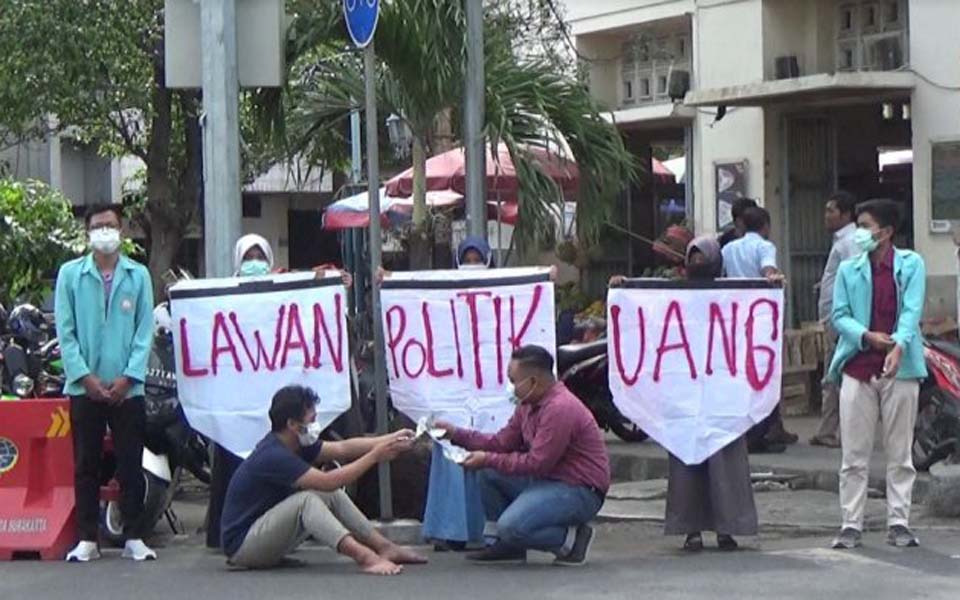 Protest banners read 'Reject Money Politics' (Tribune)