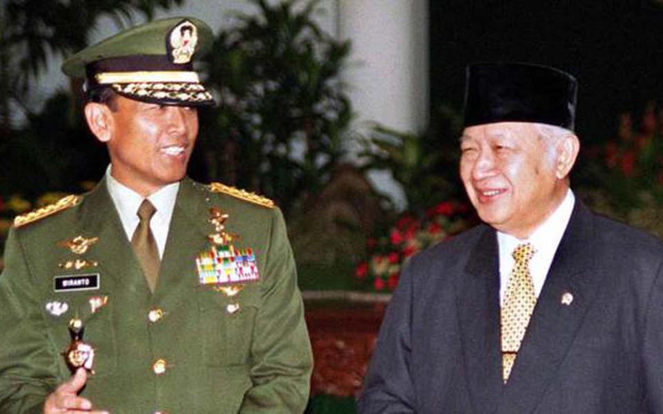 Try Sutrisno pictured left with former president Suharto (Merdeka)