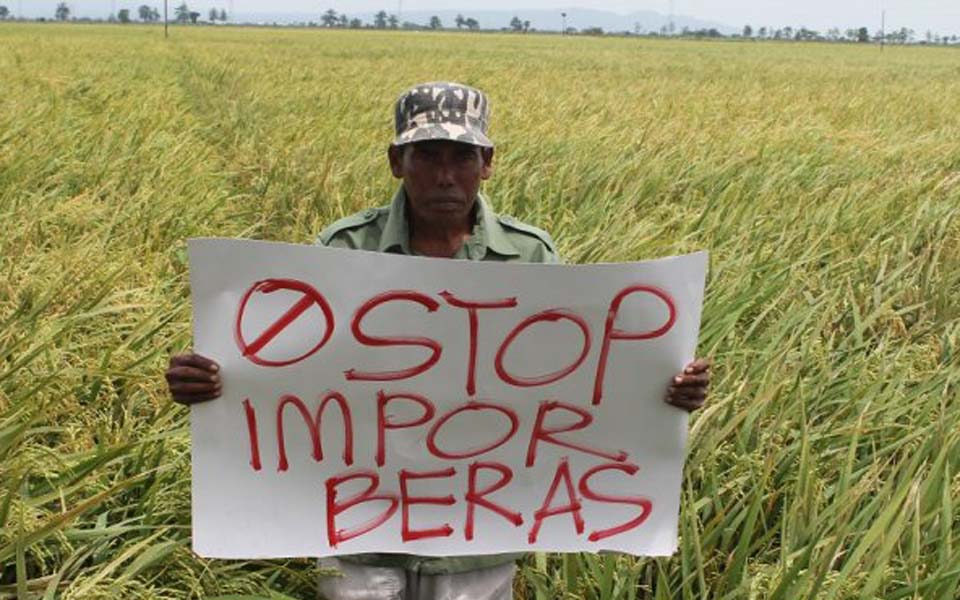 Banner reads 'Stop rice imports' (Tribune)
