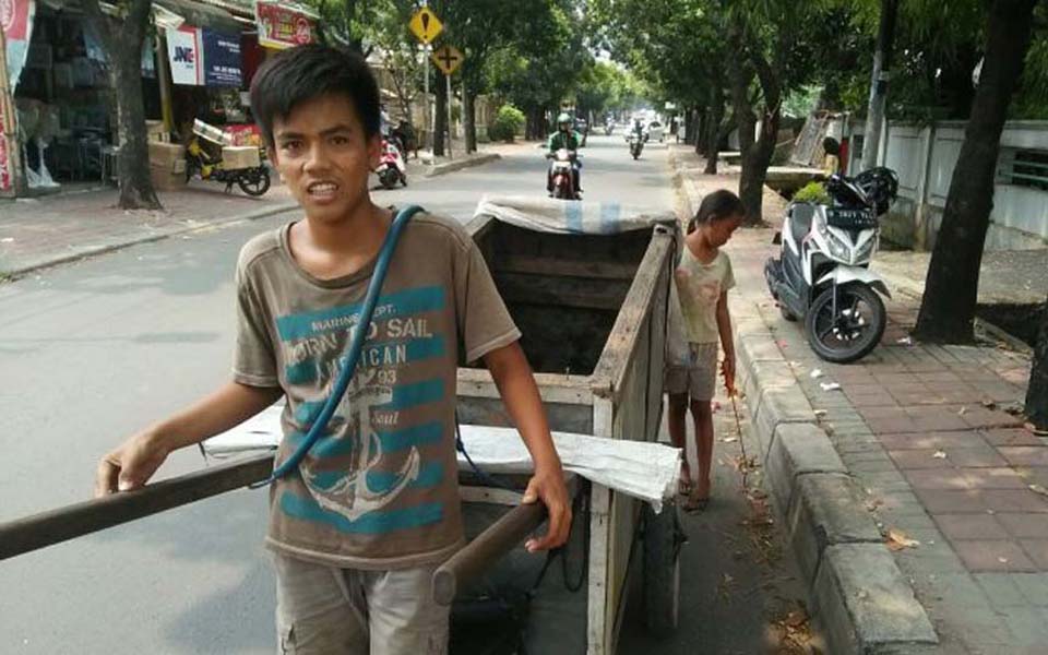 Scavenger pulling cart through Jakarta's streets (Tribune)