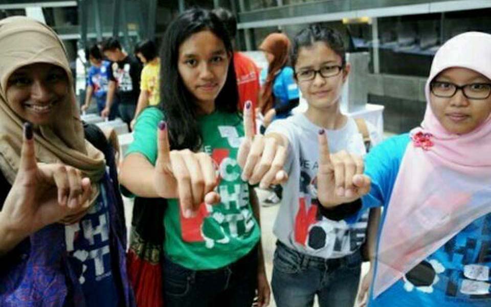 Young women show ink stained fingers after voting (tengokberita)