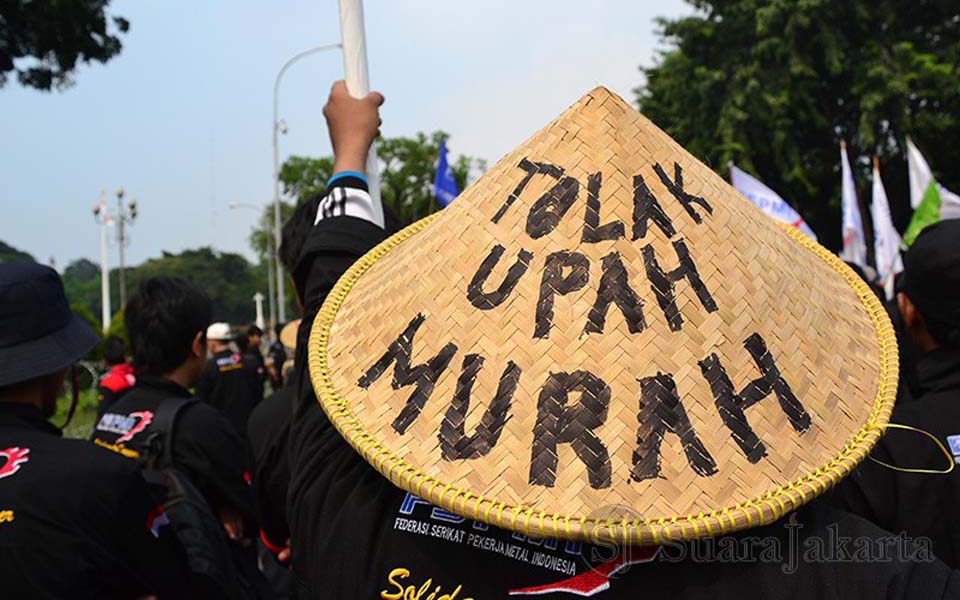 Hat reads 'reject low wages' (Koran Perdjoeangan)