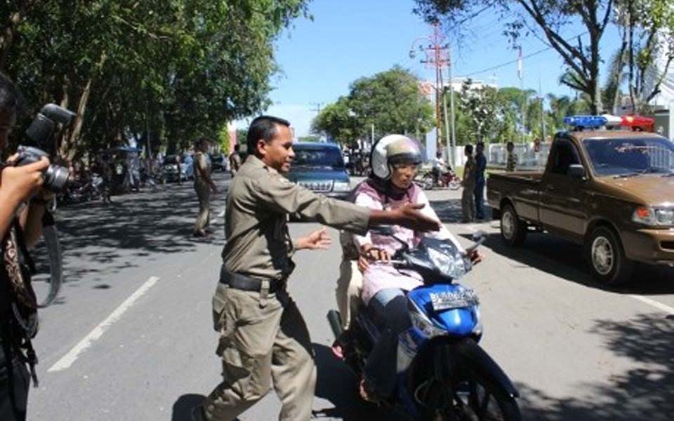 Official pulls over  woman riding on motorbike in Lhokseumawe - April 13 2013 (Detik)