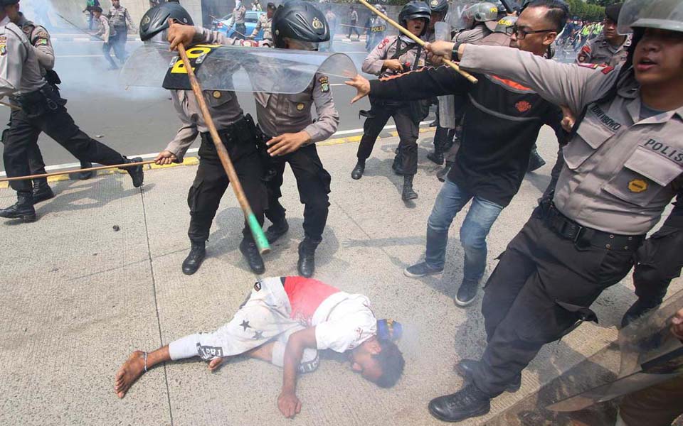 AMP protester being beaten police near Hotel Indonesia traffic circle in Jakarta - December 1, 2015 (Liputan6)