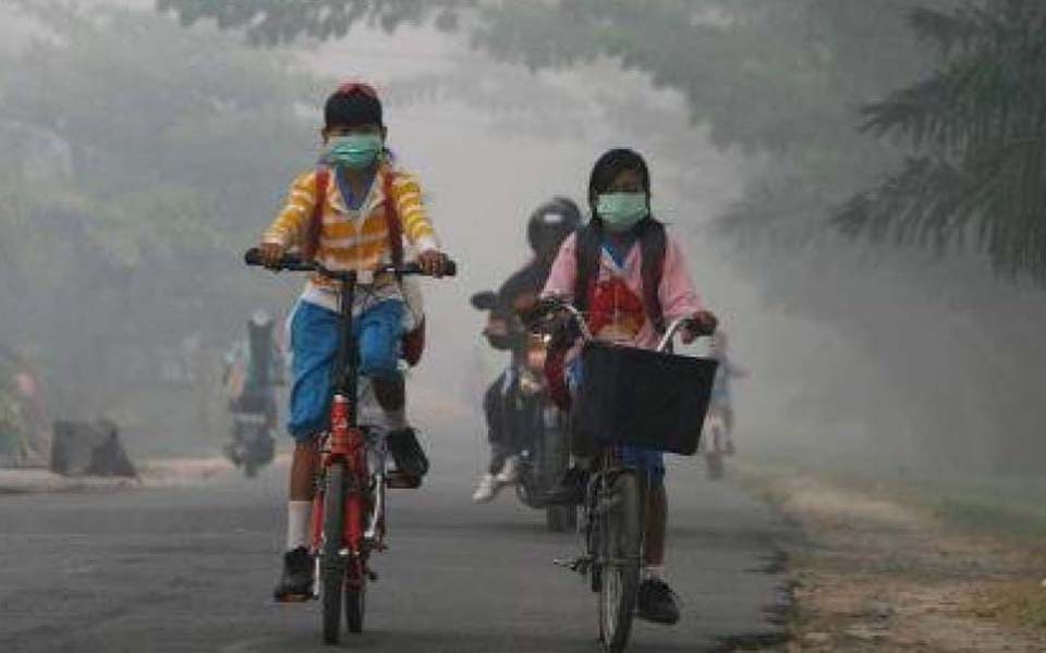 School children ride through haze from forest fires - Undated (kemkes)