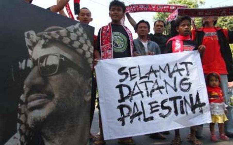 Indonesian sports fans support Palestine by holding picture of Yaser Arafat