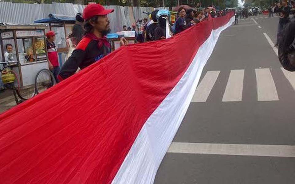 Workers unfurl national flag on May Day in Bandung - May 1, 2016 (Merdeka)