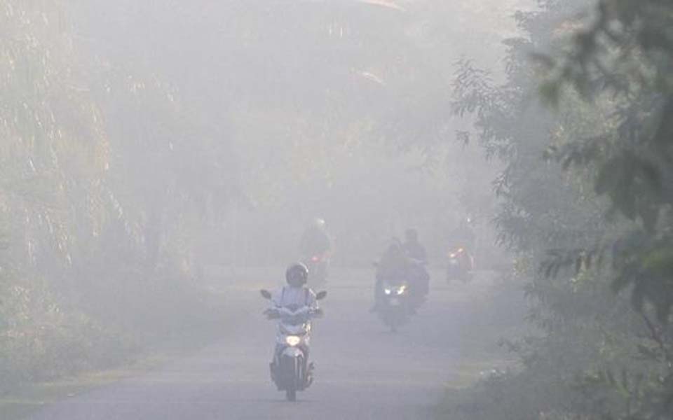 Motorists drive through haze from forest fires (Antara)