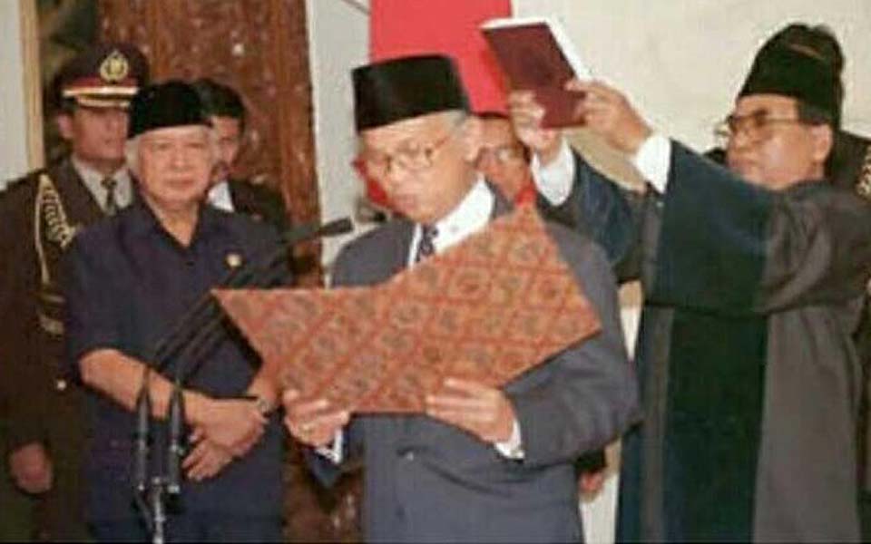 Suharto (left) watches Habibie being sworn in as president – May 21, 1998