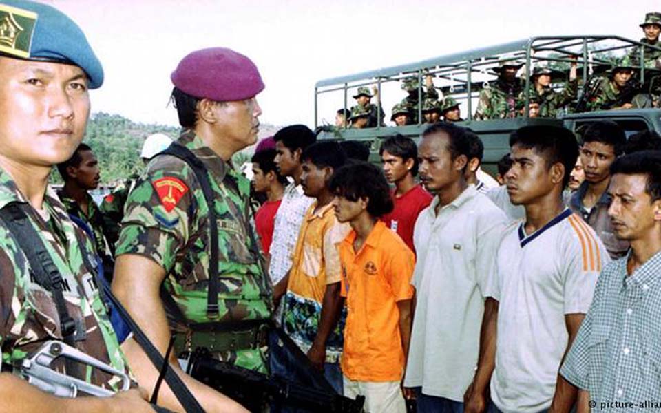 Indonesian soldiers guard GAM prisoners in Aceh (DW)