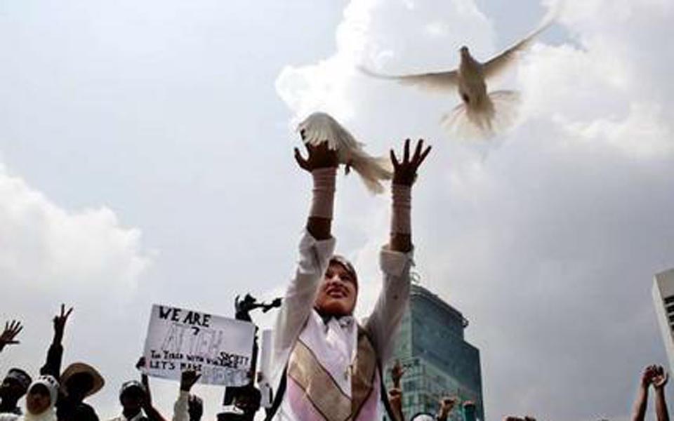 Protester releases doves at rally for peace in Aceh (elsam)