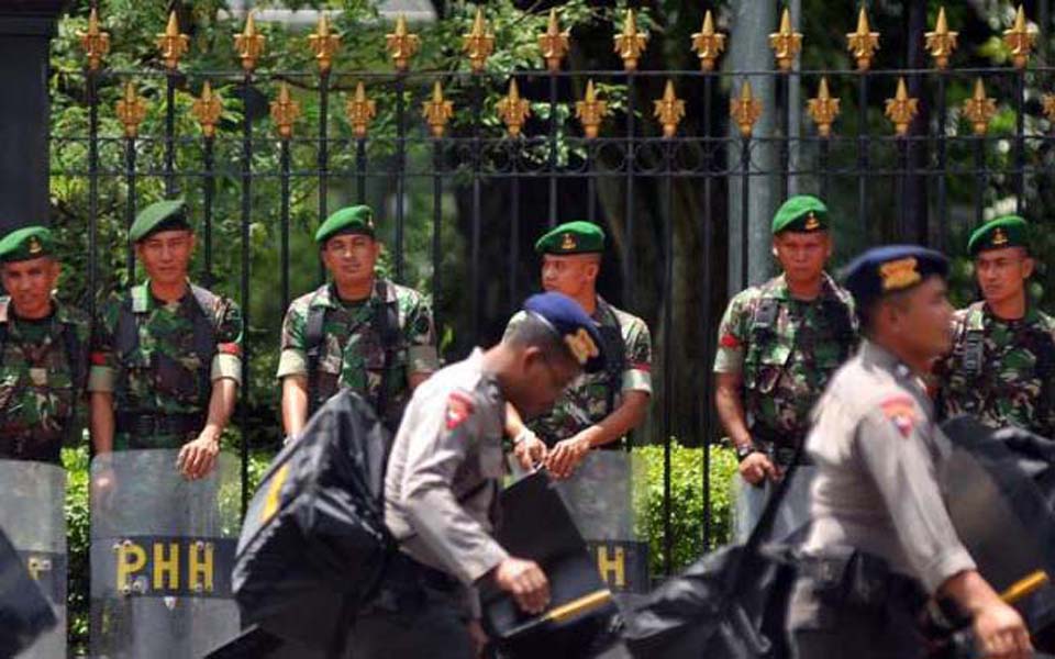 Brimob officers walk past TNI soldiers (simomot)