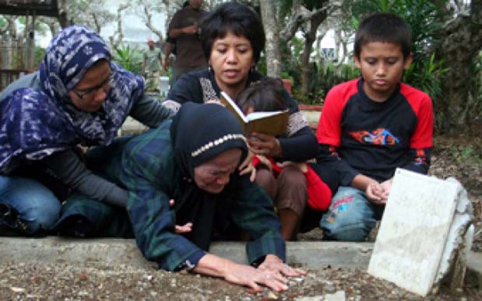 Suciwati with her two children and family members at Munir's grave (Tempo)