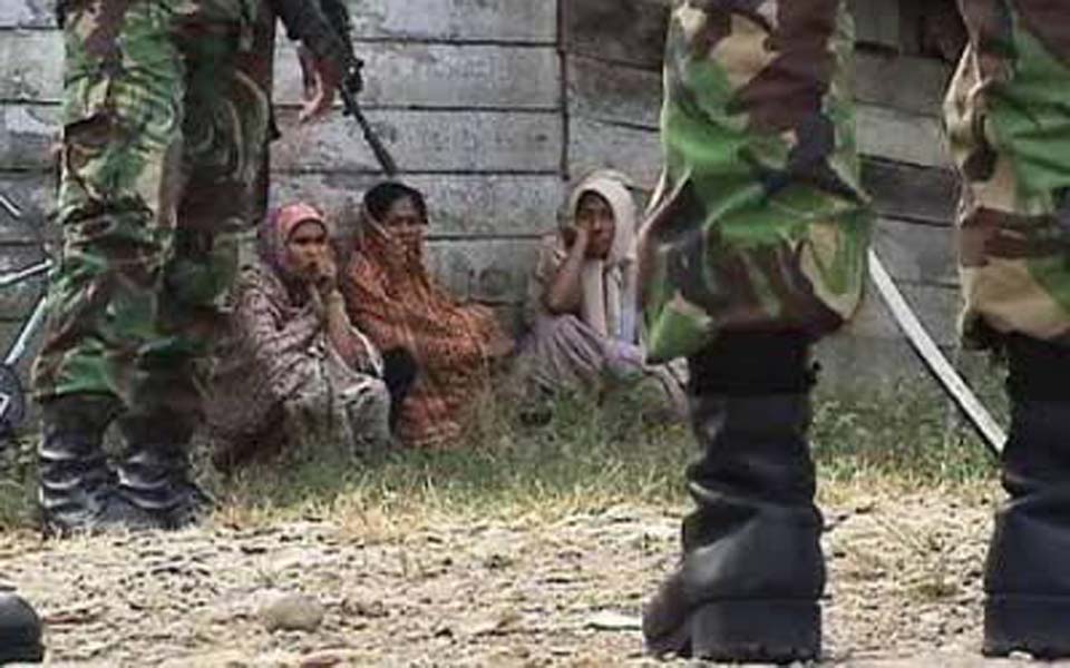 Villagers watch Indonesian soldiers on patrol in Aceh (Aceh Trend)