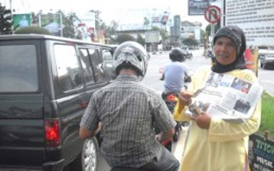 Woman sells newspapers on streets of Banda Aceh (Kompasiana)