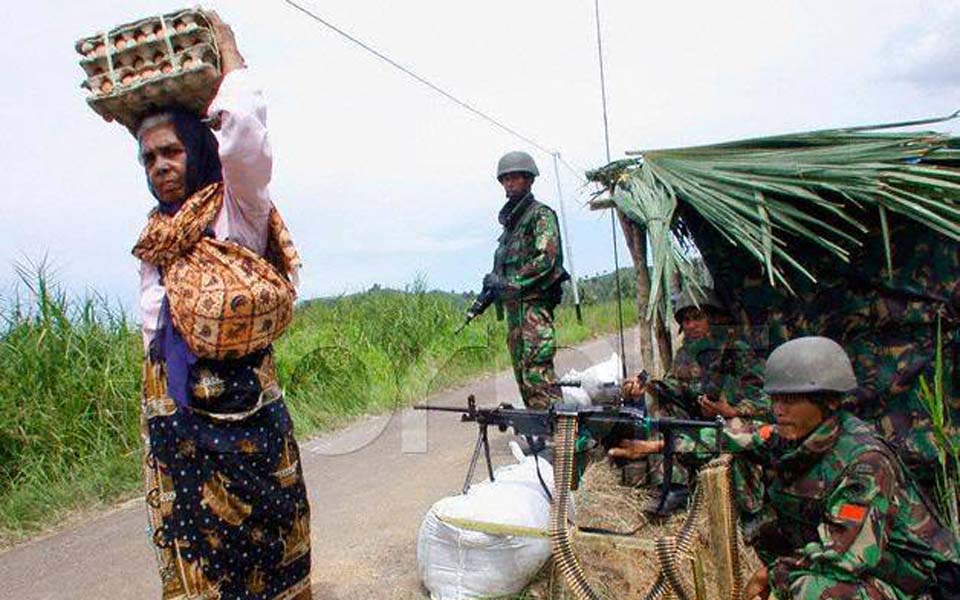 Women walks past TNI soldiers in Aceh (xlaceh)