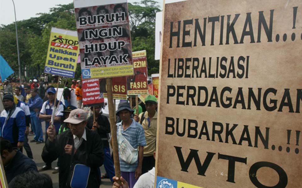 Banner reads 'End Trade Liberalisation Disband the WTO' (Satu Harapan)