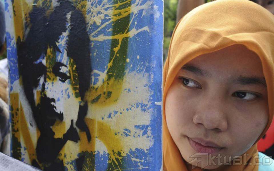 Protester from Munir Solidarity Committee hold picture of Munir (Aktual)