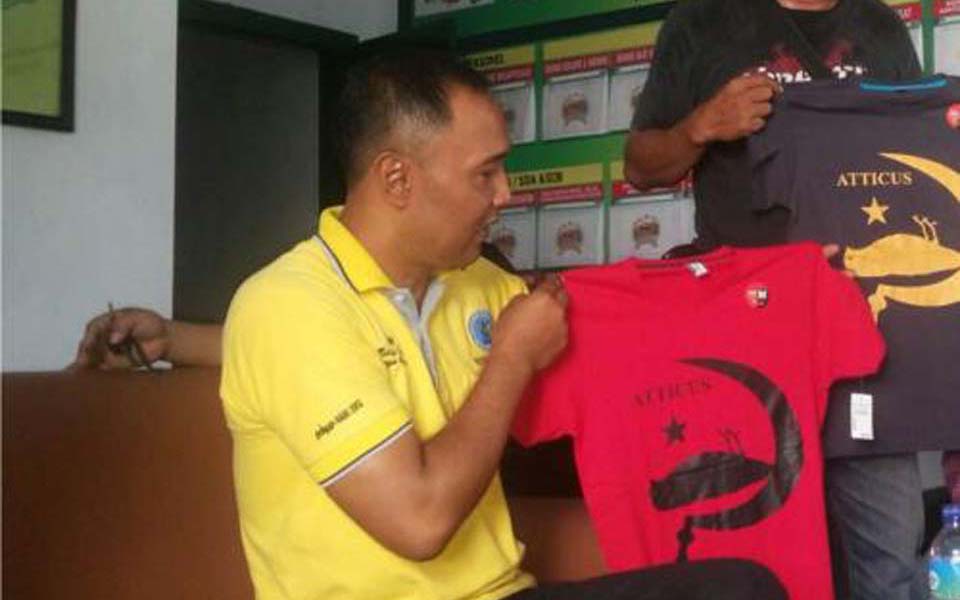 Plain clothed police officers display confiscated hammer-and-sickle T-shirts (Berita Jatim)