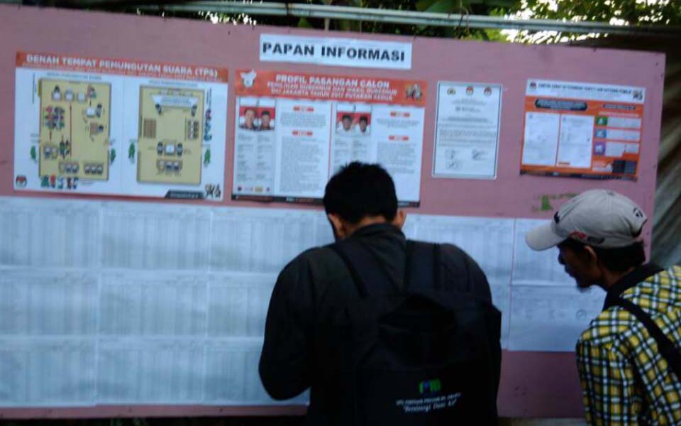 People check for their names on voter registration list in Jakarta (Arah)