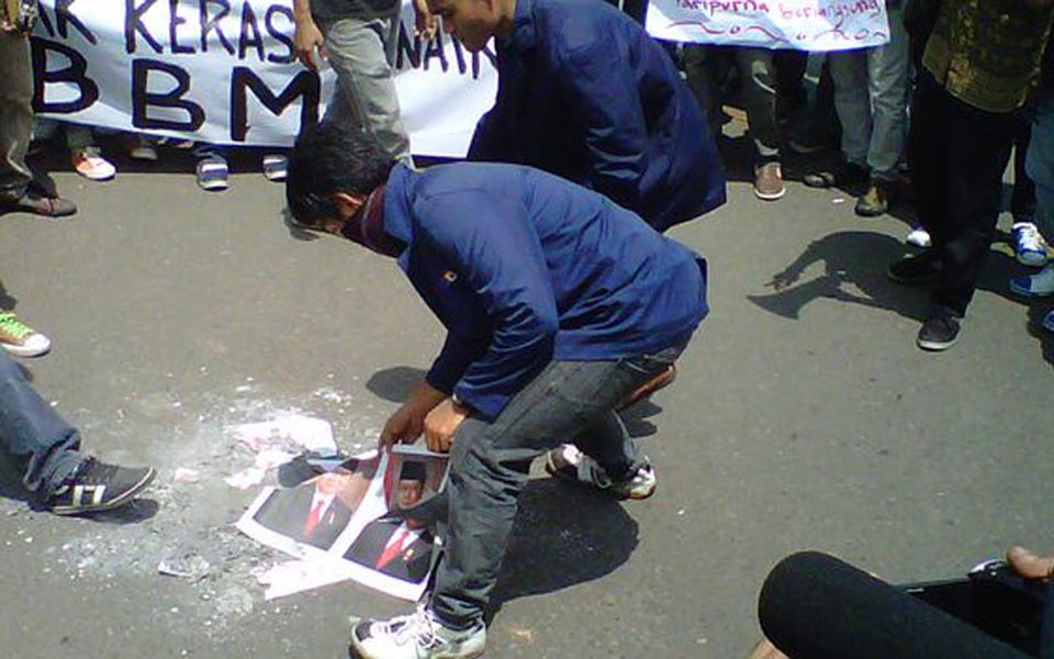 Protester tramples on burnt pictures of SBY and Boediono (Tribune)