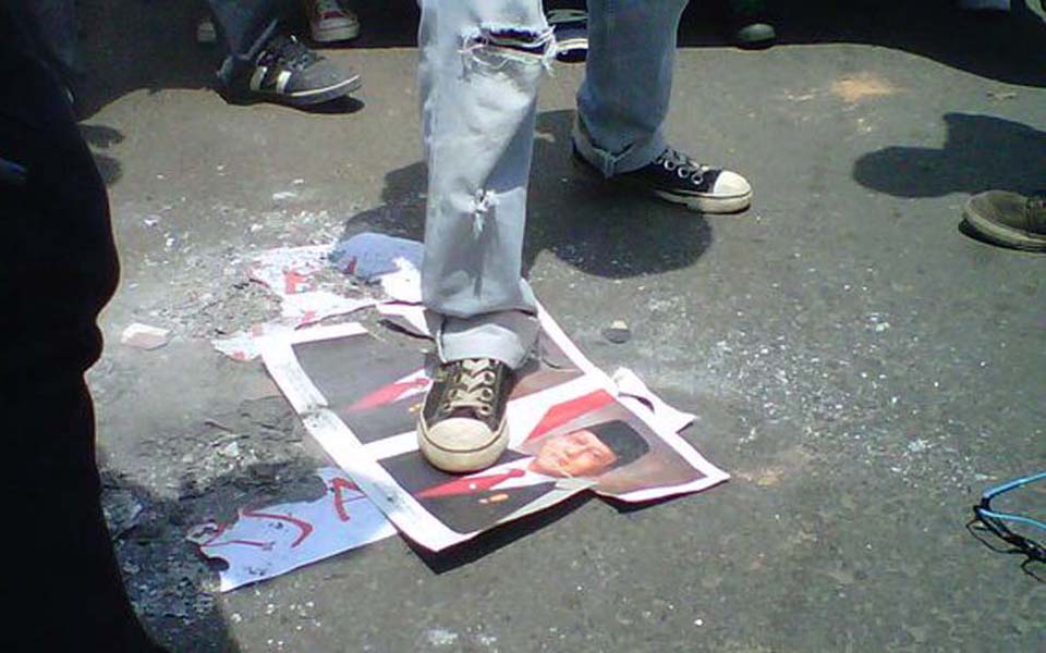 Protester tramples on burnt pictures of SBY and Boediono (Tribune)