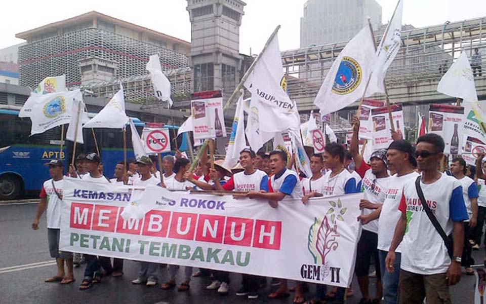 Banner reads 'Killing Tobacco Farmer' (Pos Kota News)