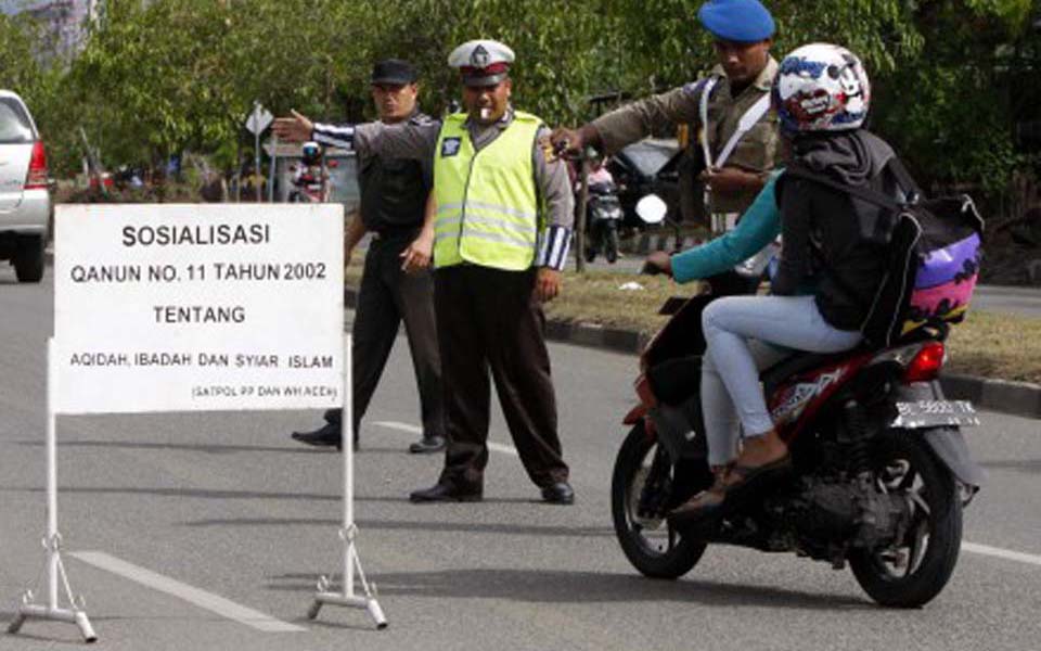Police checkpoint stops woman riding on motorbike in Lhokseumawe - January 4, 2013 (Kompasiana)