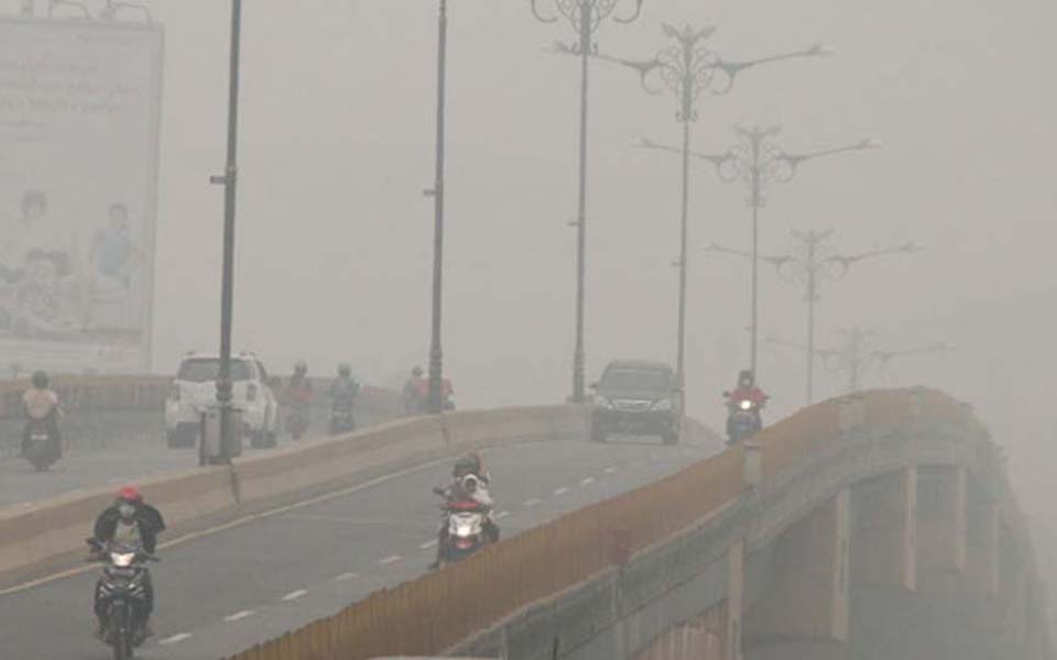 Driver cross bridge covered in haze from forest fires in Pekanbaru, Riau - September 30, 2015 (Antara)