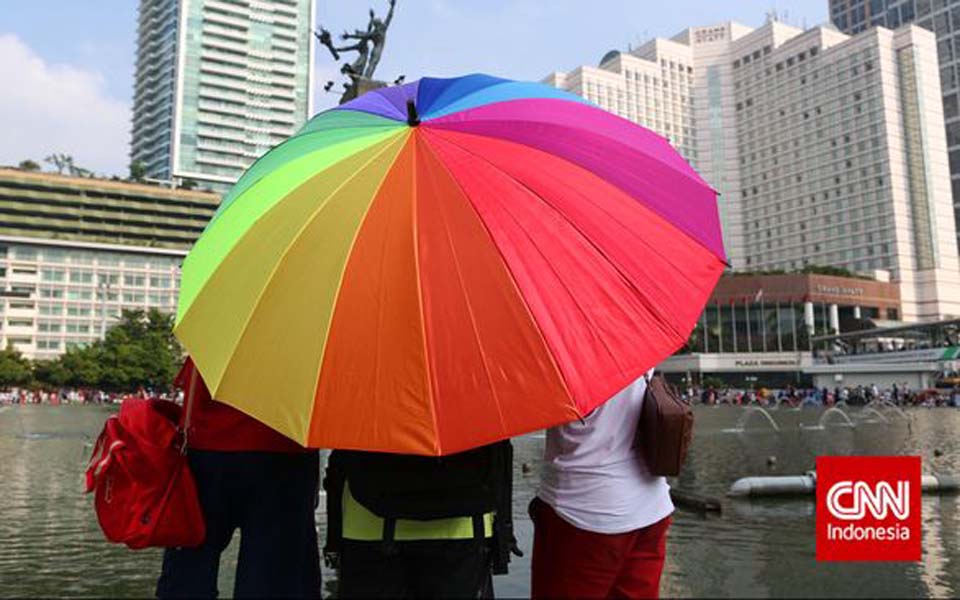 People hold rainbow umbrella at Hotel Indonesia traffic circle – Undated (CNN)