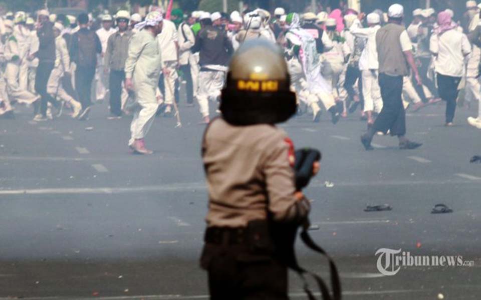 Police officer confronts FPI mob throwing rocks at Jakarta parliament – October 3, 2014 (Tribune)